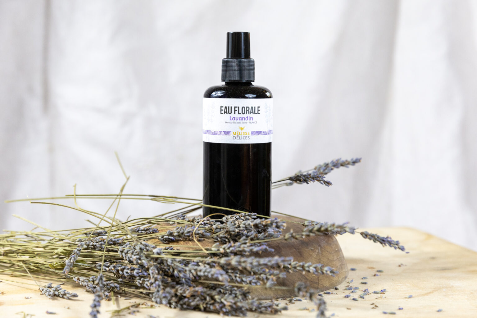 Eau florale de lavande Mélisse Délices mise en scène avec des brins de lavande